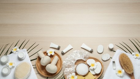 Photo of Flat lay composition with shower cap and spa stones on wooden background. Space for text