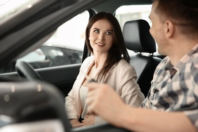 Young couple sitting in auto. Buying new car