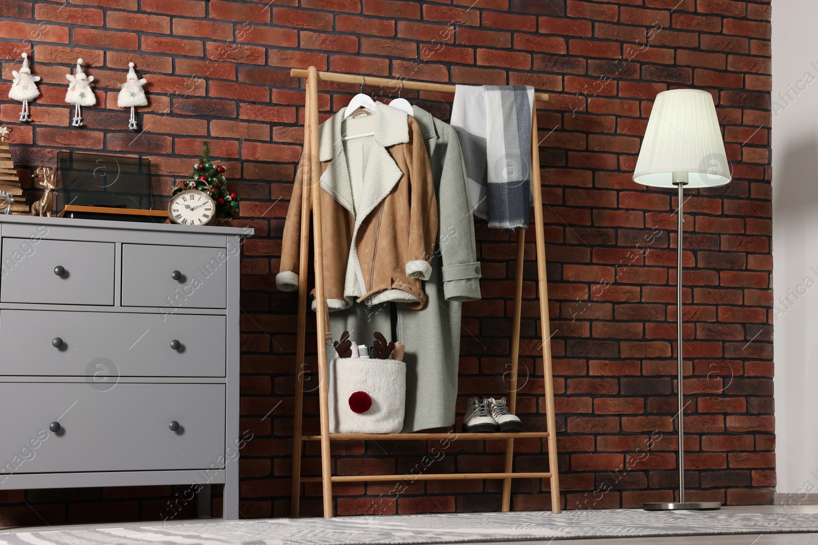 Photo of Modern hallway interior with Christmas decor and stylish furniture near red brick wall