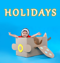 Image of School holidays. Cute little child playing with cardboard plane near blue wall