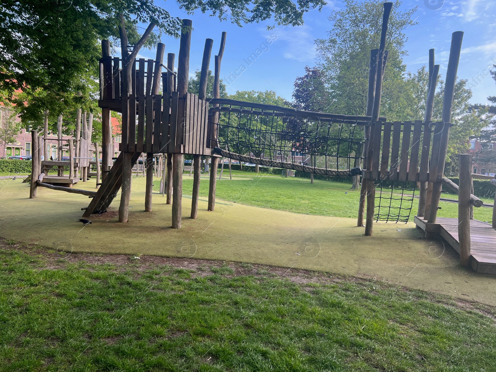Photo of Empty wooden playground and trees in park