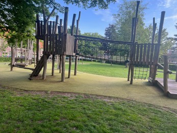 Photo of Empty wooden playground and trees in park