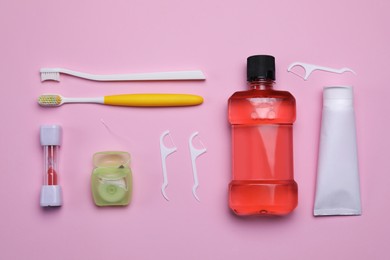 Photo of Flat lay composition with tongue cleaners and teeth care products on pink background