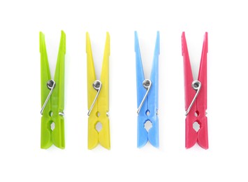 Photo of Colorful plastic clothespins on white background, top view