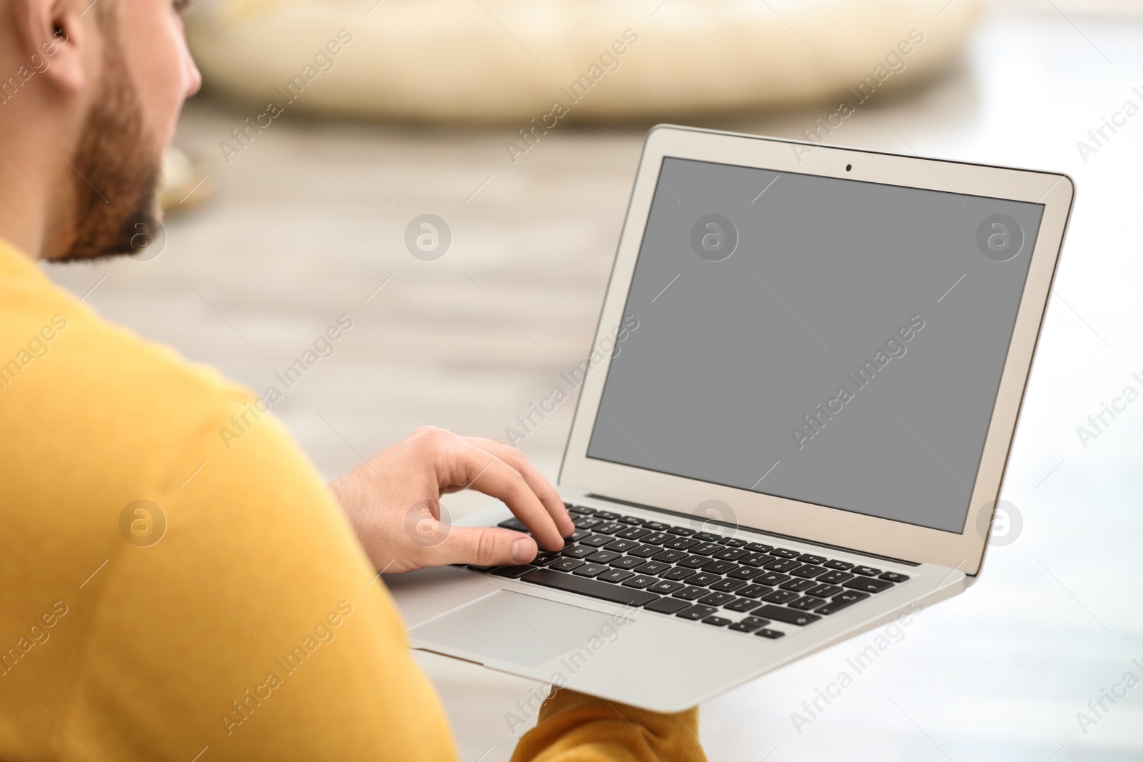 Photo of Young man using video chat on laptop at home, closeup. Space for design