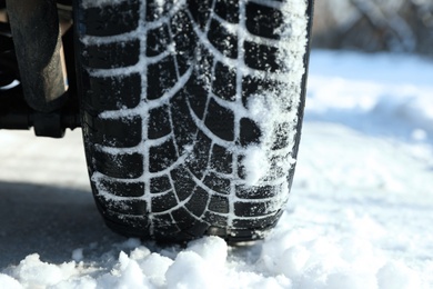 Photo of Car with winter tires on snowy road, closeup view