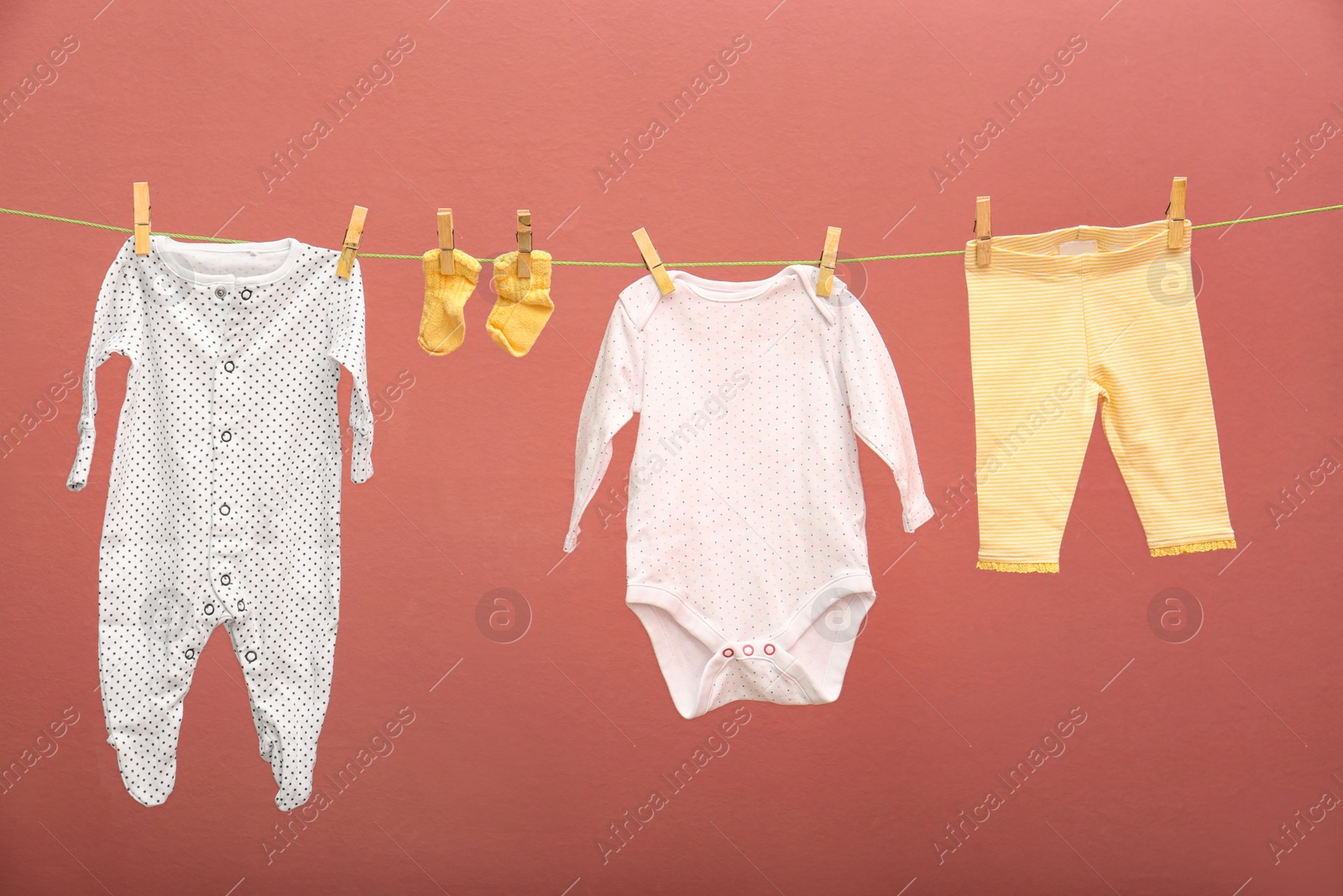 Photo of Children's clothes on laundry line against color background