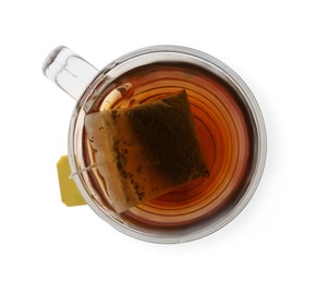 Photo of Tea bag in glass cup of hot water isolated on white, top view