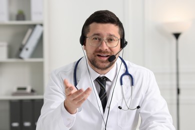 Photo of Doctor in headset having online consultation in clinic