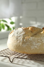 Photo of Freshly baked sourdough bread on white wooden table indoors