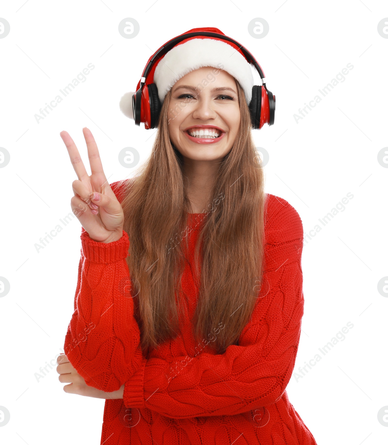 Photo of Young woman in Santa hat listening to Christmas music on white background