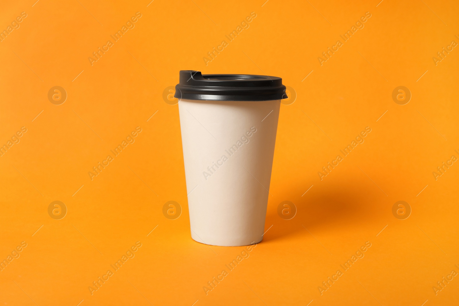 Photo of Takeaway paper coffee cup on orange background