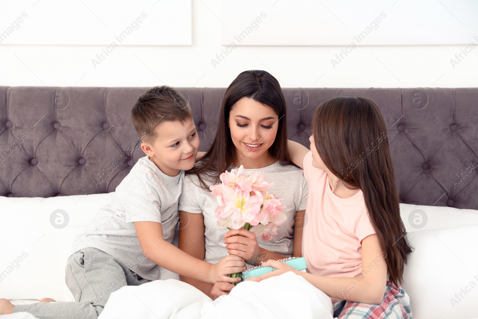 Photo of Son and daughter congratulating mom in bed. Happy Mother's Day