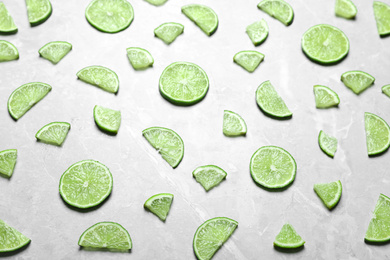 Slices of fresh juicy lime on marble table, above view