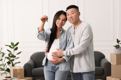 Pregnant woman and her husband with key in their new apartment