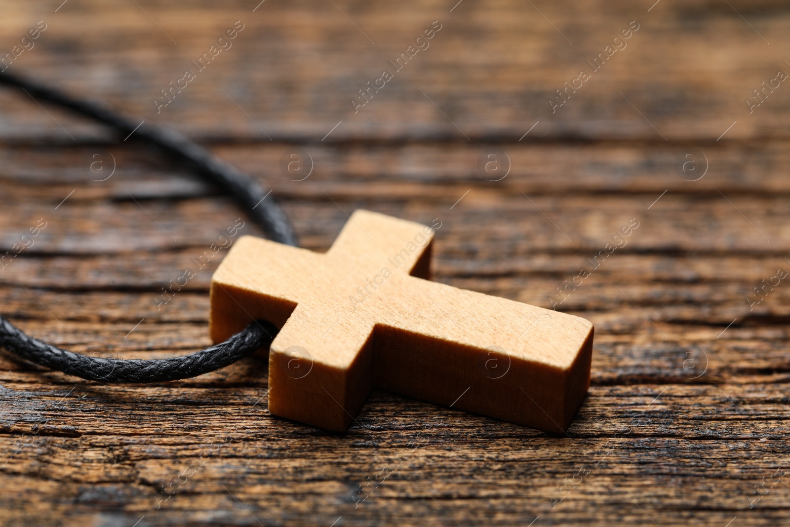 Photo of Wooden Christian cross on table, closeup view