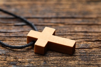 Photo of Wooden Christian cross on table, closeup view