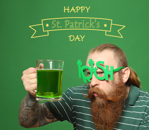 Image of Man in party glasses with green beer on color background. St. Patrick's Day celebration