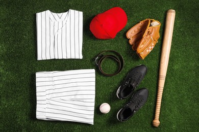 Photo of Flat lay composition with baseball equipment on artificial grass