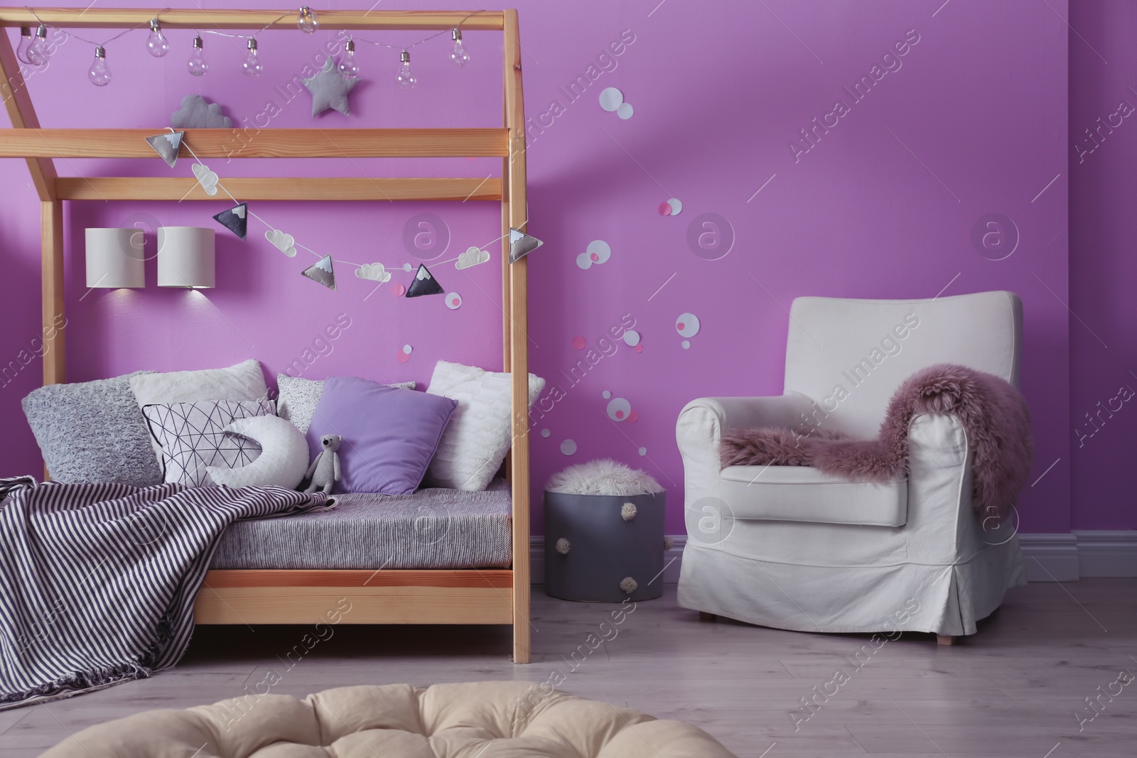 Photo of Child's room interior with comfortable bed and garland