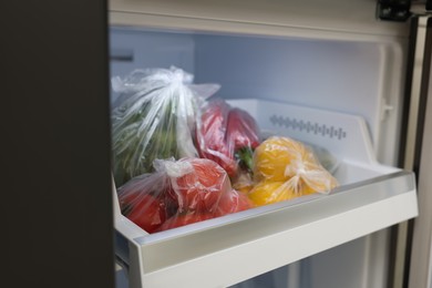 Plastic bags with different fresh products in refrigerator, closeup