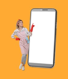 Housewife using big smartphone on orange background