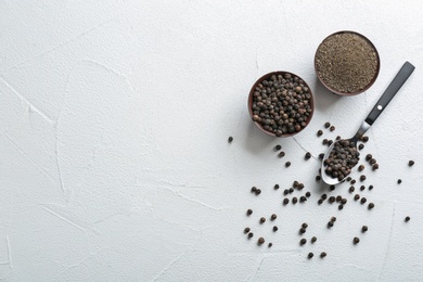 Ground black pepper and corns on light table, top view. Space for text