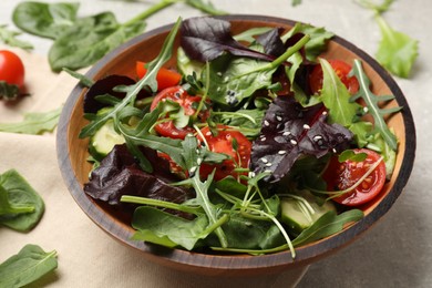 Photo of Tasty fresh vegetarian salad and ingredients on grey table, closeup