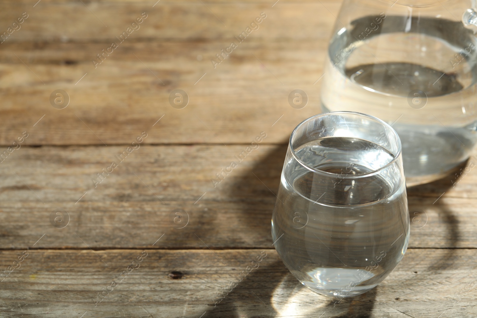 Photo of Glass of water on wooden table, space for text. Refreshing drink