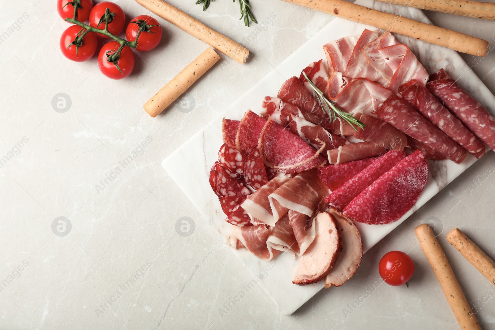 Photo of Flat lay composition with different meat delicacies and space for text on gray background