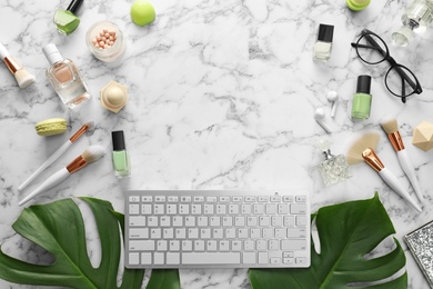 Flat lay composition with keyboard on marble table. Beauty blogger's workplace