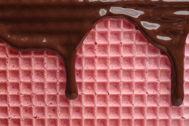 Photo of Hot dark chocolate on wafer, closeup. Crispy food