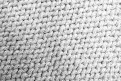 Grey knitted sweater as background, closeup view