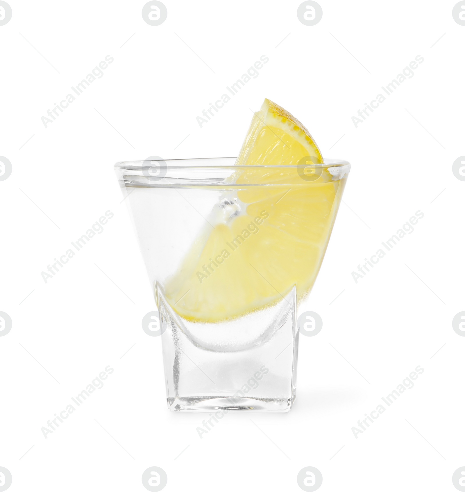 Photo of Shot glass of vodka with lemon isolated on white