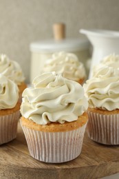 Photo of Tasty vanilla cupcakes with cream on table, closeup