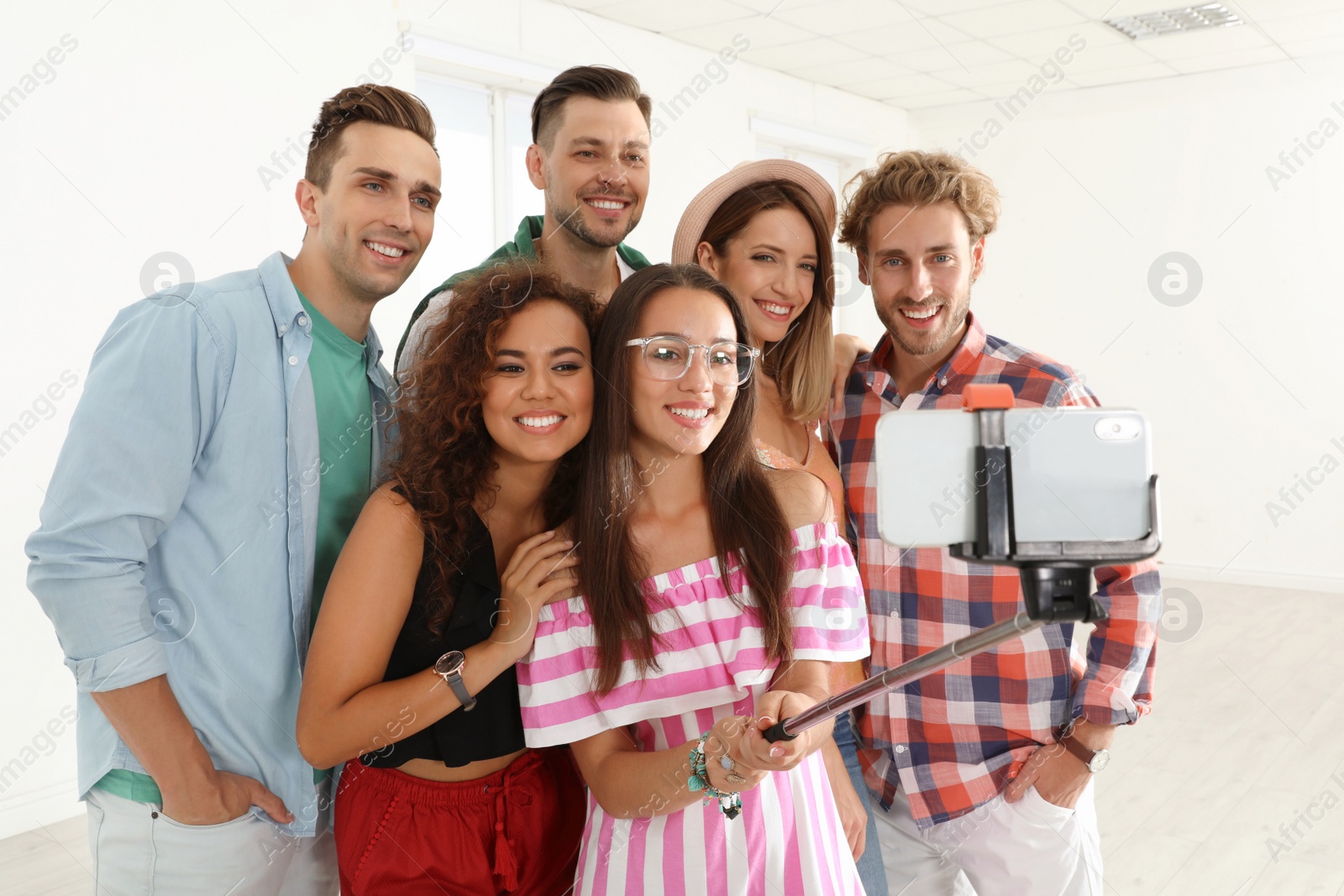 Photo of Group of happy young people taking selfie indoors