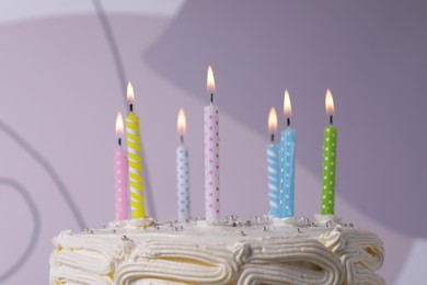 Delicious cake with cream burning candles on color background, closeup