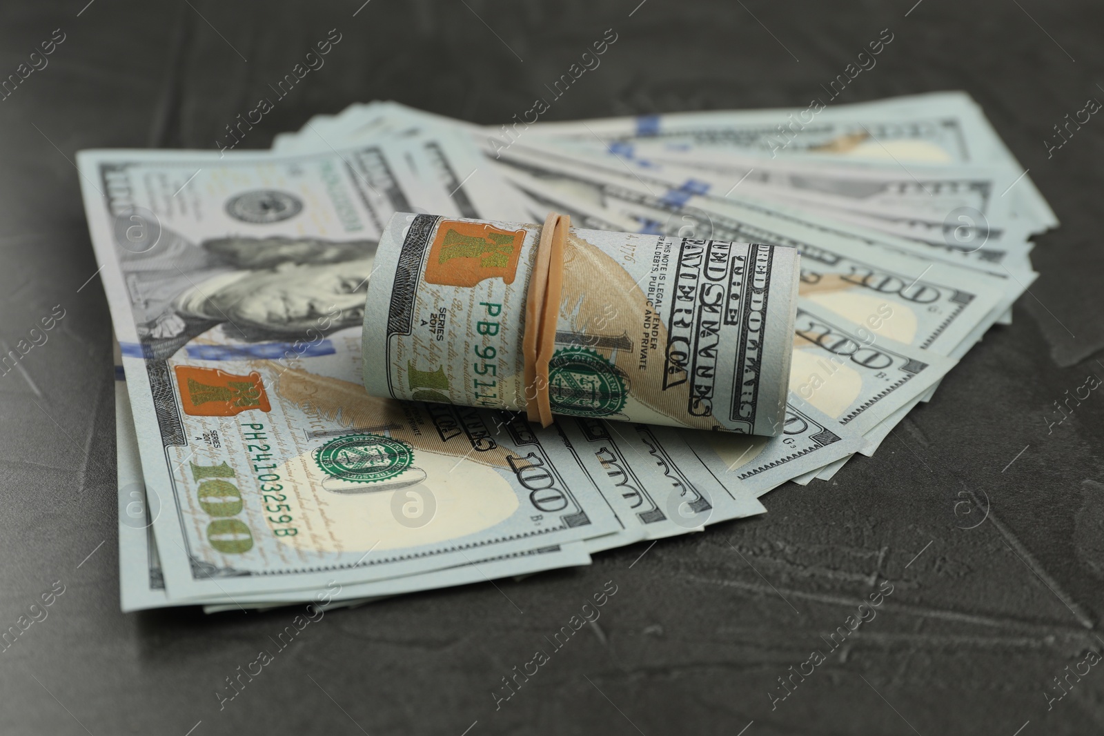 Photo of Money exchange. Dollar banknotes on dark gray textured background, closeup