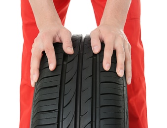 Photo of Hands of mechanic with car tire on white background