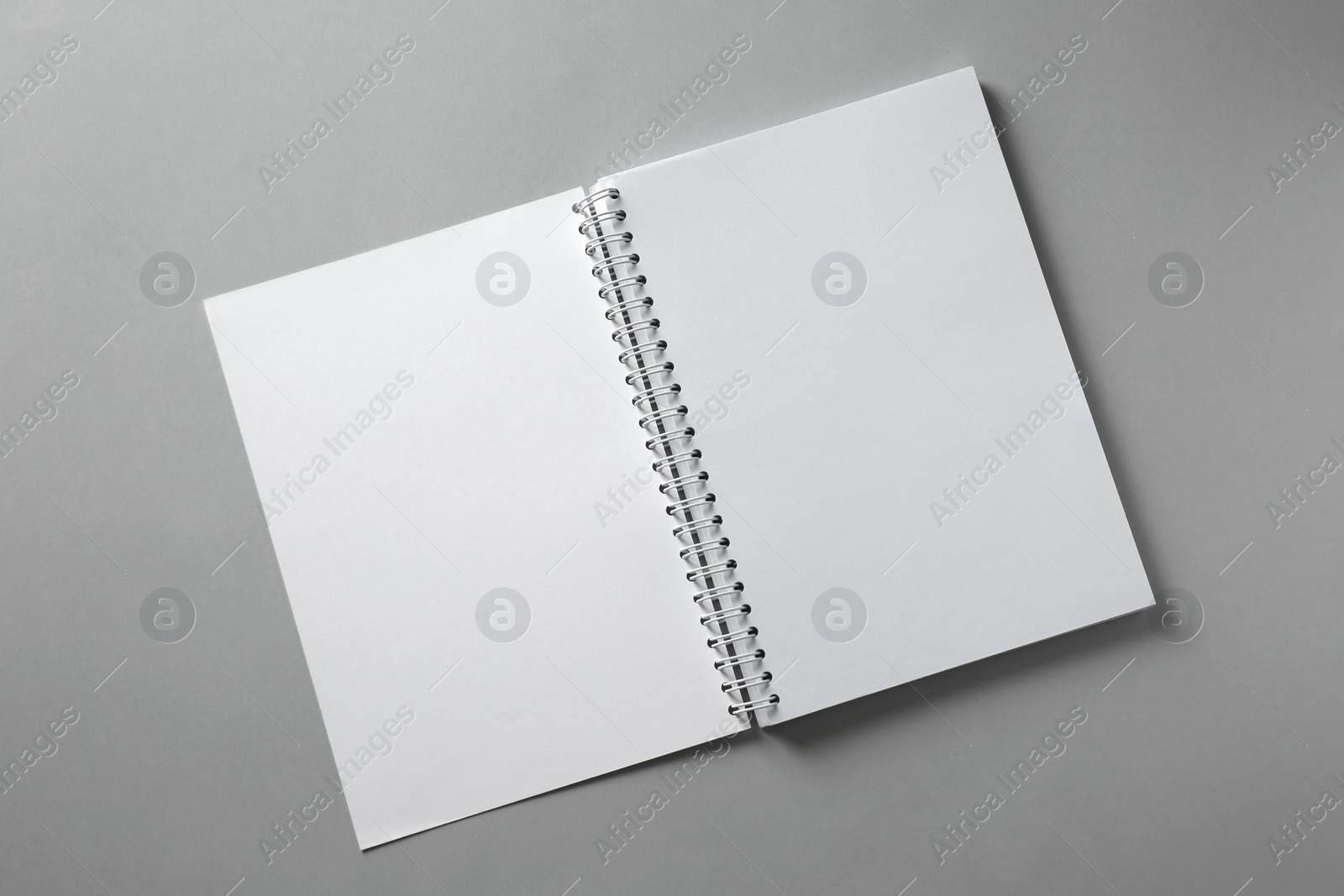 Photo of Open blank notebook on grey background, top view. Mockup for design