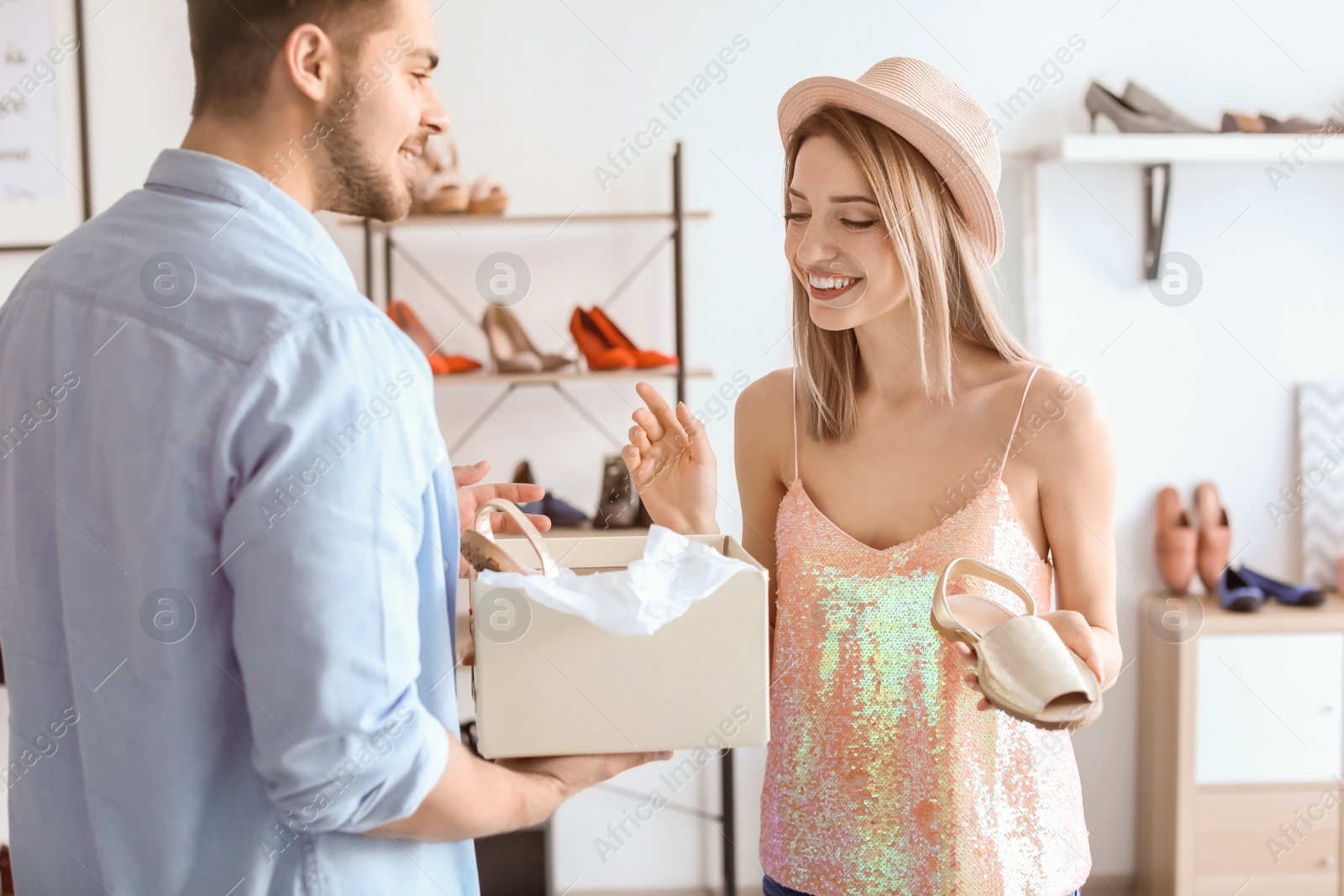 Photo of Young couple choosing shoes in store