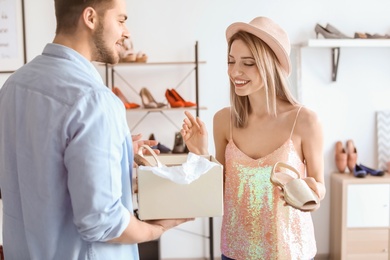 Young couple choosing shoes in store