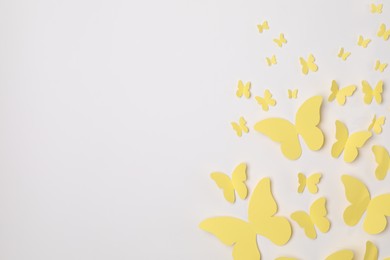 Photo of Yellow paper butterflies on white background, top view. Space for text