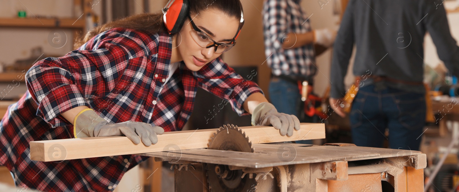Image of Professional carpenter working with sawmill machine in workshop. Banner design