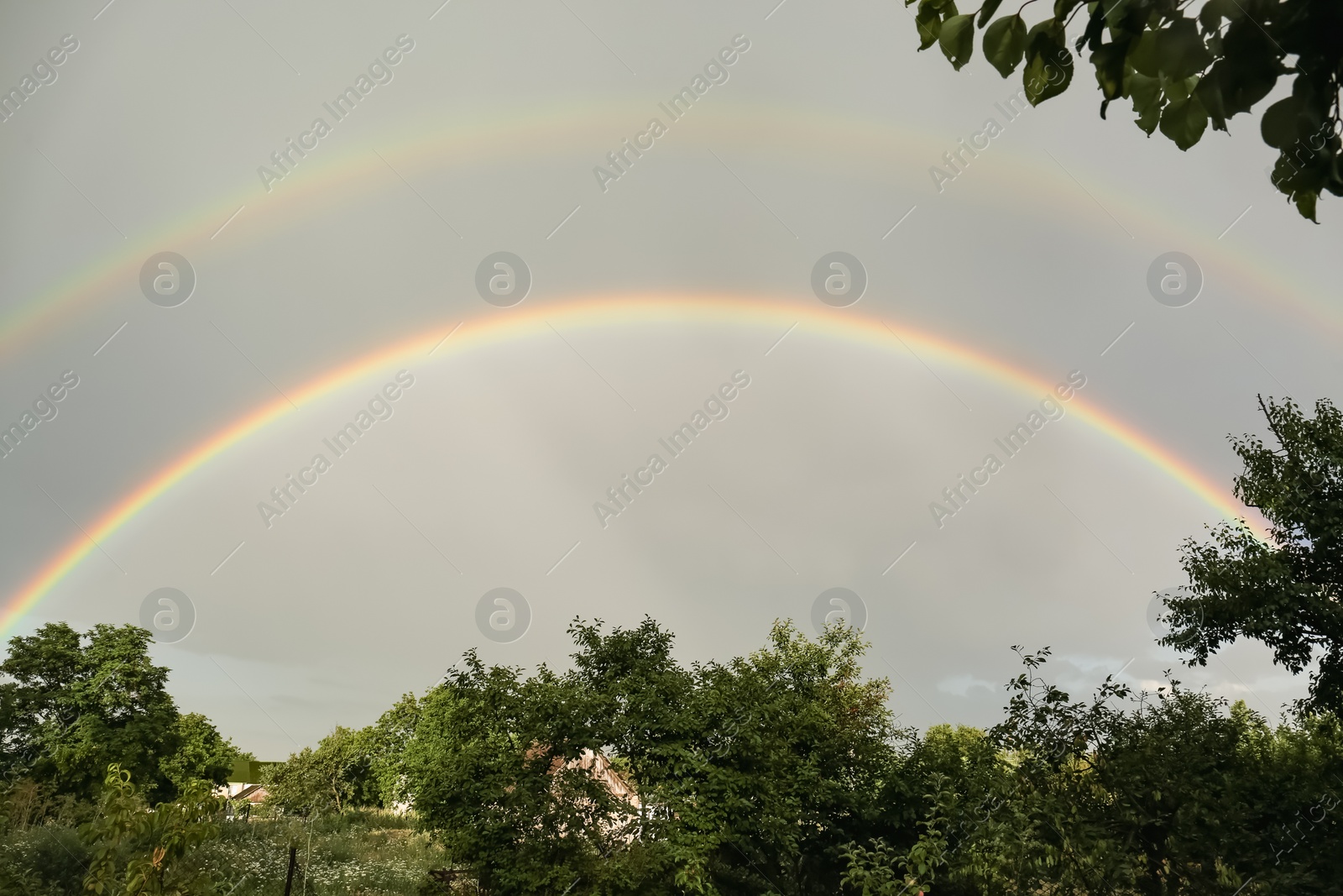 Photo of Beautiful view of countryside and double rainbow in cloudy sky
