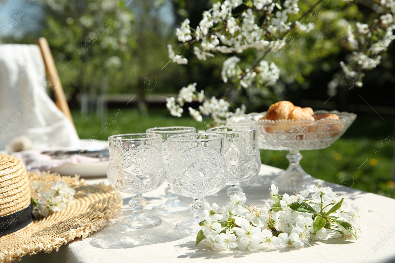 Photo of Beautiful table setting with spring flowers in garden on sunny day