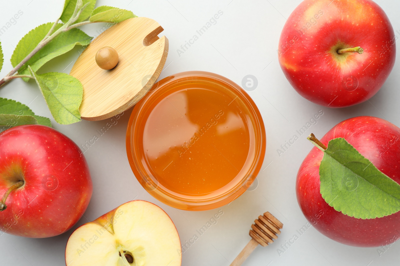 Photo of Sweet honey and fresh apples on white table, flat lay