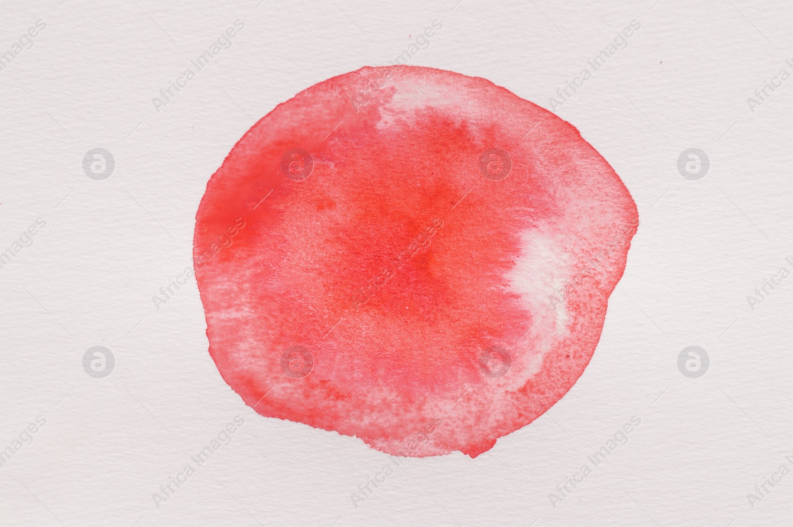 Photo of Blot of red watercolor paint on white paper, top view