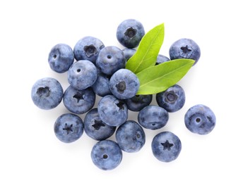 Photo of Pile of tasty fresh blueberries and green leaves on white background, top view