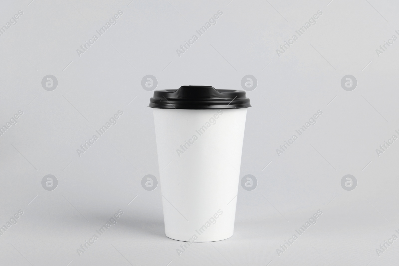 Photo of Paper cup with plastic lid on light background. Coffee to go